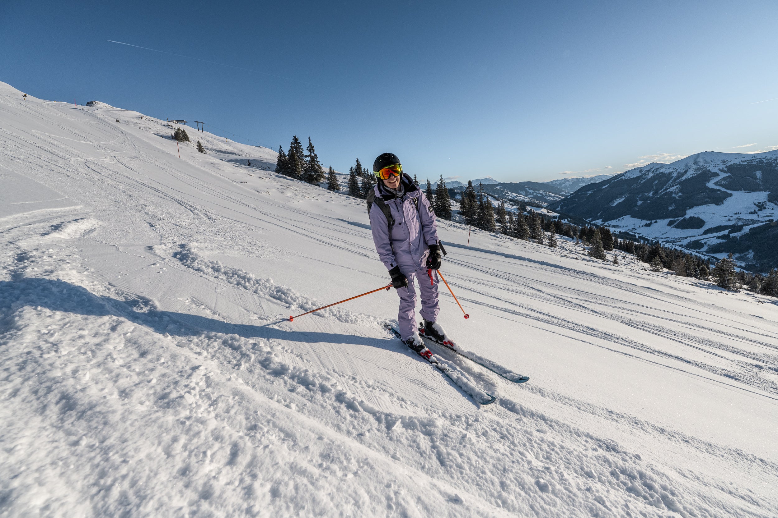 Skifahrerin auf präparierter Piste vor Bergpanorama