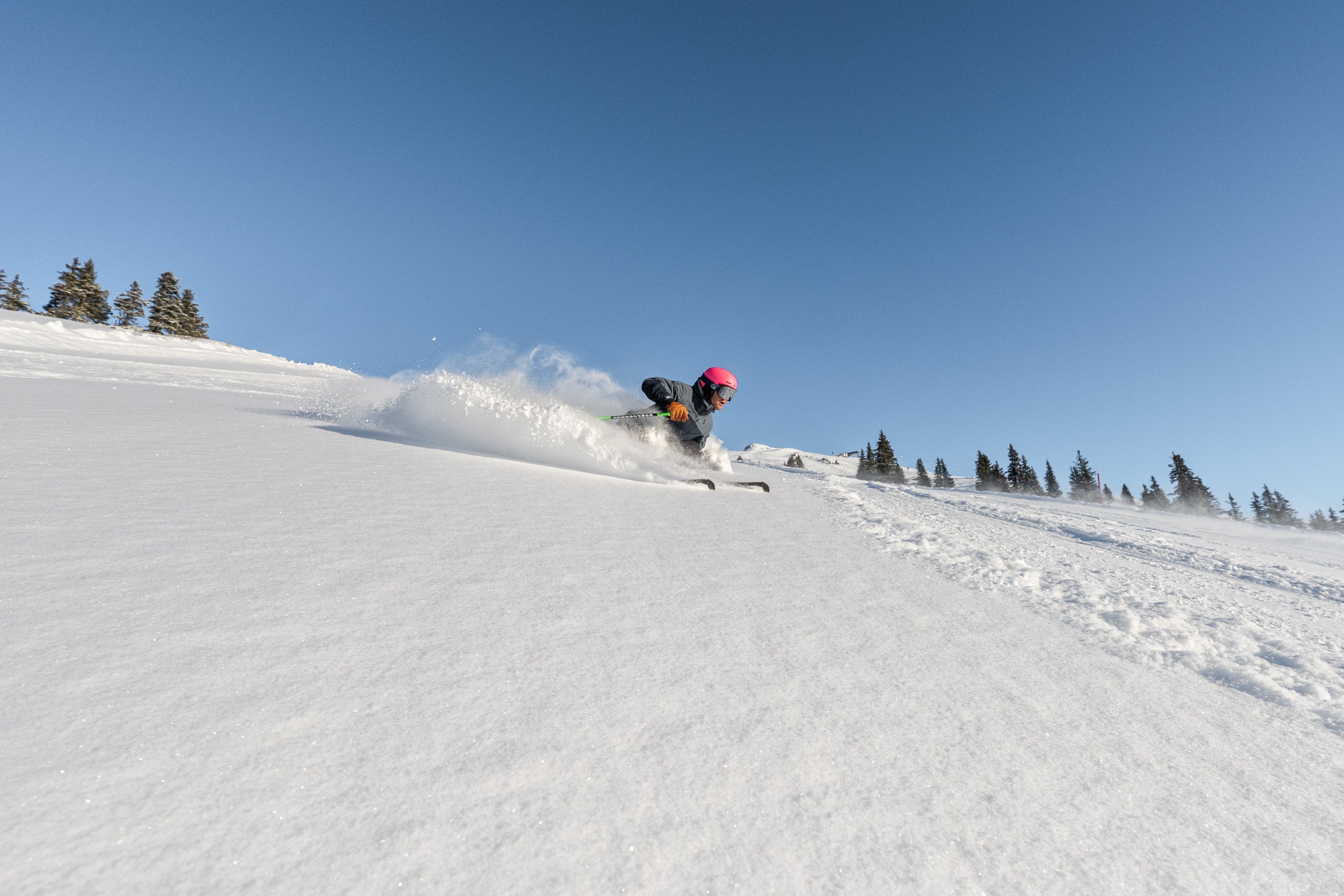 Dynamischer Tiefschnee-Schwung im Sonnenlicht